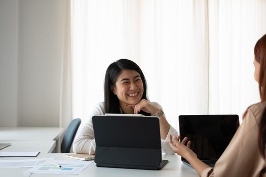 Asian female advisor meeting with customer financial. Young beautiful candidate at job interview in modern office space. Business consulting or employment concept