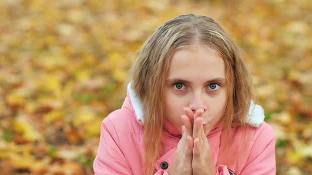 Teenage girl freezes in the autumn park