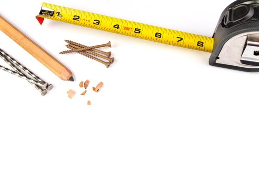 High Angle Close up of a Carpenter's Pencil with Sharpening Shavings, Tape Measure, Framing Nails and Deck Screws on a white background. High quality photo