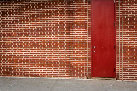 Great background of a garage of orange bricks with a red door