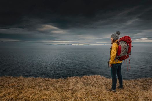 Female backpacker traveller in Iceland watching the Ocean