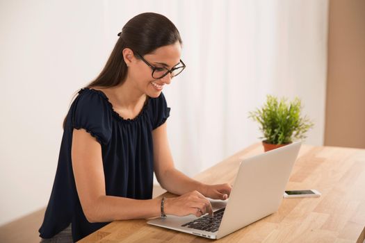 Portrait of a happy businesswoman sitting at her desk in a home office