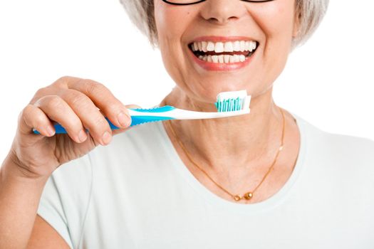 Portrait of a happy old woman brushing her teeth