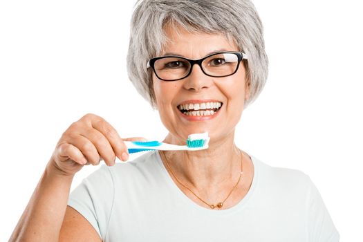 Portrait of a happy old woman brushing her teeth