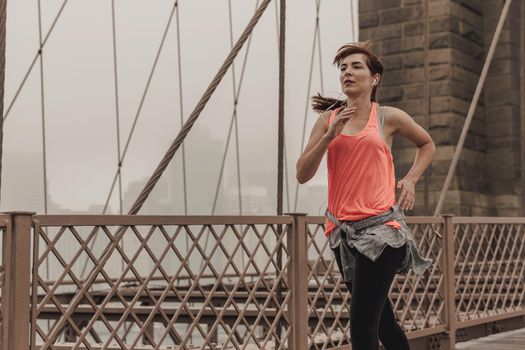 Woman practicing jogging on the Brooklyn bridge