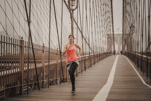 Woman practicing jogging on the Brooklyn bridge