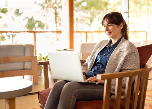 Woman working on a laptop on a cozy space