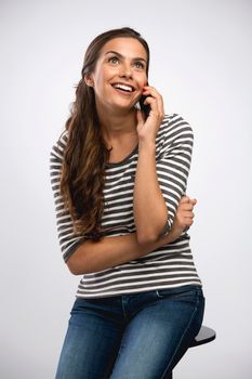 Beautiful happy young woman sitting on a bench making a phone call