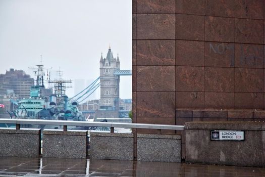 London, United Kingdom - October 7th, 2006: No 1 London Bridge building, with HMS Belfast and Tower Bridge over river Thames in background, shot on rainy overcast day.