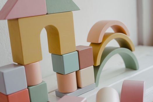 Child development concept. Toys made of natural wood. Logical thinking. Wooden blocks and cubes - house on white background.