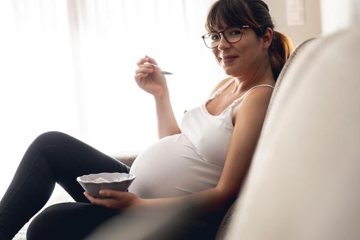 Pregnant woman working at home resting and eating healthy food