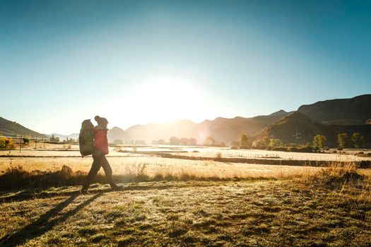 Shot of a woman walking with a backpack at sunrise