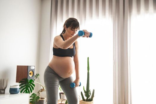 Pregnant woman doing exercises at home