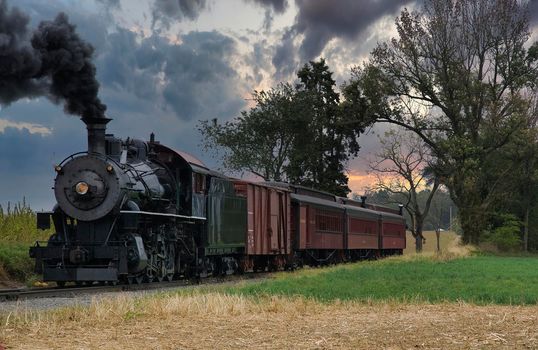 An Antique Restored Steam Freight Train Approaching Head on Blowing Smoke and Steam