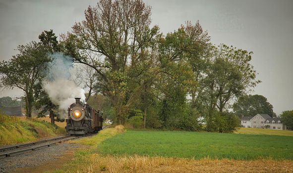 An Antique Restored Steam Freight Train Approaching Head on Blowing Smoke and Steam