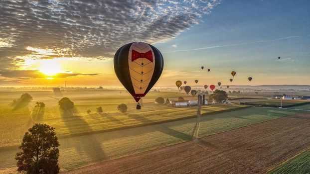 Bird in Hand, Pennsylvania, September 2019 - Aerial View of Many Hot Air Balloons In Flight Thru Rural Countryside On An Early Morning Balloon Festival