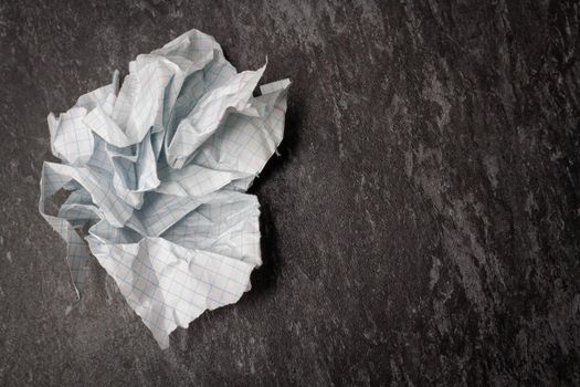 Crumpled and torn paper on the table. Torn piece of notebook. Paper trash. Full basket of notes. Notepad and pencil on crumpled paper background.