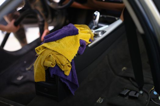 Microfiber towels in the car, interior cleaning, close-up, blurry. Professional car dry cleaning service
