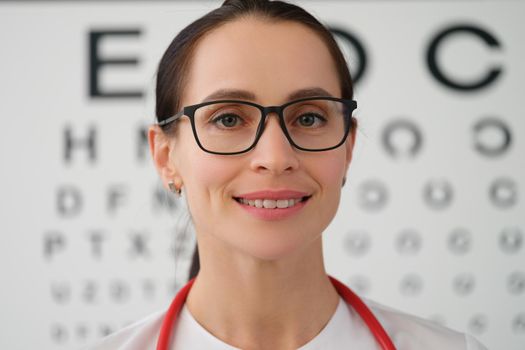 Portrait of female doctor ophthalmologist with glasses, close-up. Eyesight tests. Professional selection of lenses for vision