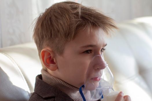 Little boy having inhalation for easing cough. Caucasian blonde boy inhales couples containing medication to stop coughing. Medical procedures. Inhaler. Respiratory medicine.