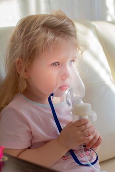 Little girl having inhalation for easing cough. Caucasian blonde girl inhales couples containing medication to stop coughing. Medical procedures. Inhaler. Respiratory medicine.