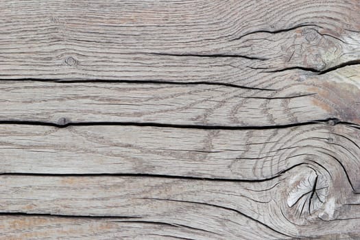 Textured background of beige sawn wood with cracks, horizontal lines, top view, close-up.