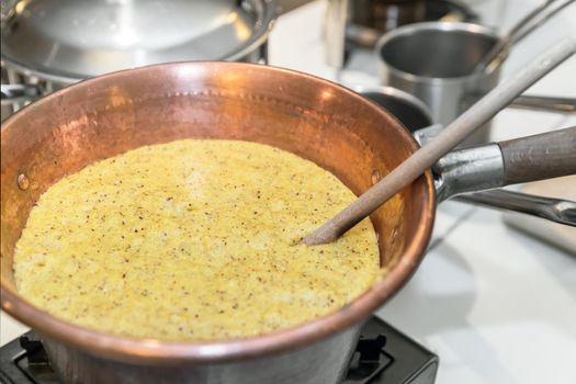 Polenta. Typical dish from Bergamo cooked in the traditional copper pot.