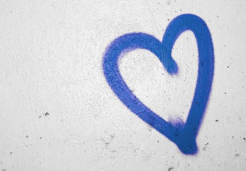 Concept or conceptual painted blue abstract heart shape love symbol, dirty wall background, metaphor to urban and romantic valentine, grungy style.