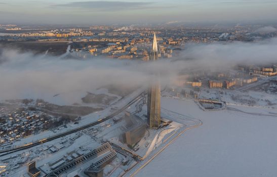 Russia, St. Petersburg, 08 January 2022: Lakhta center skyscraper in a winter frosty evening at sunset, the future main building of the office of the oil company Gazprom, buildings of pink color. High quality photo