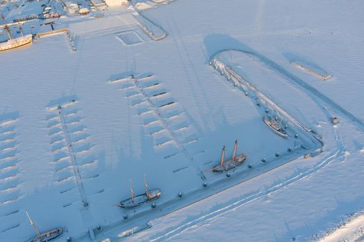 an empty new port and several vintage frigates under the snow on a frosty winter evening. High quality photo