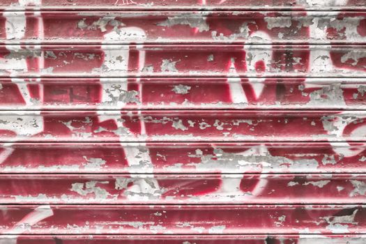 Red metal shutter with peeling paint. Ideal use for background / wallpaper.
