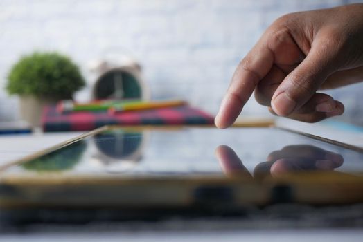 child hand pointing finger on digital tablet screen.
