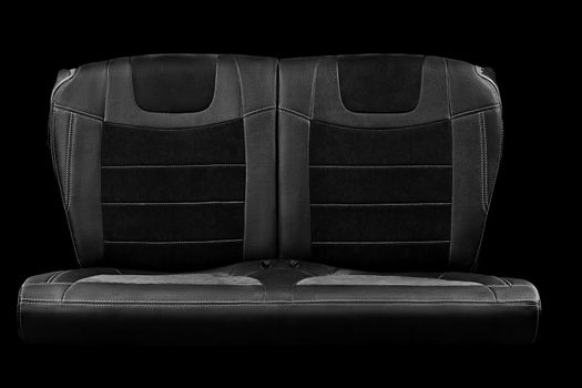 Comfortable double rear passenger car seat in faux leather with suede inserts isolated on black background, front view