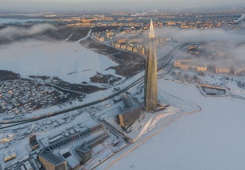 Russia, St. Petersburg, 08 January 2022: Lakhta center skyscraper in a winter frosty evening at sunset, the future main building of the office of the oil company Gazprom, buildings of pink color. High quality photo