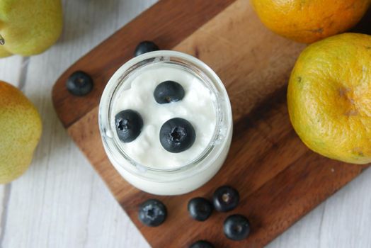 close up of fresh yogurt with blue berry in a bowl .