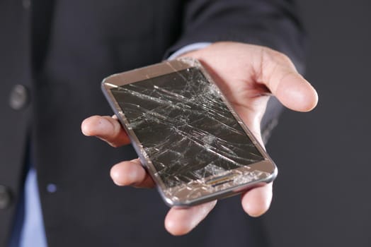 Close up of man hand holding broken smart phone