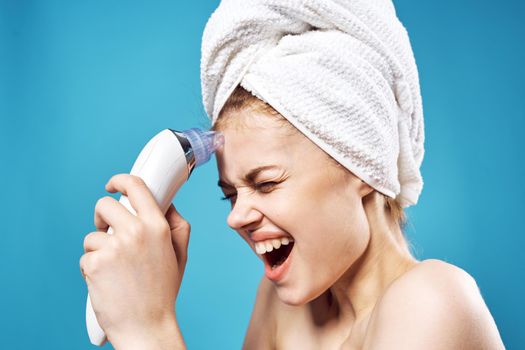 woman with towel on head cleaning face skin care blue background. High quality photo