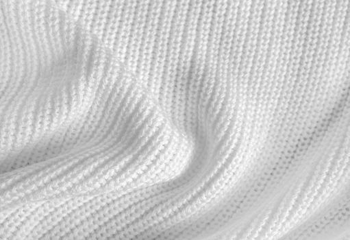 Soft knitted sweater texture closeup. Light abstract background. The trendy white backdrop for web design. Luxury twisted fabric backplate with patterns