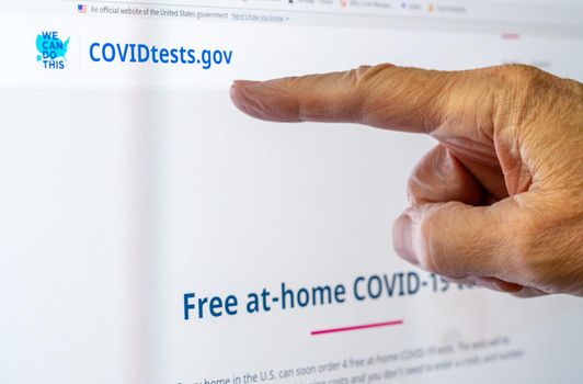 Morgantown, WV - 14 January 2022: Screen shot of the new federal government website for ordering the free at-home Covid-19 tests with senior hand