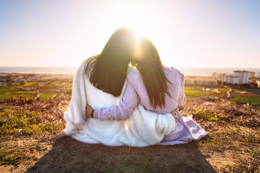 Two best girlfriends or sisters hugging and enjoying life at sunset. Friends spending time together. Friends forever. High quality photo