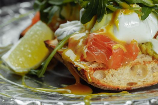 Eggs Benedict with avocado toast. Delicious and healthy breakfast. Healthy food concept.
