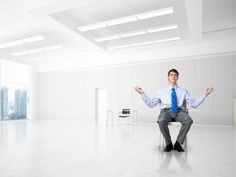 young businessman in the office meditates, achieve calmness, to achieve the goal