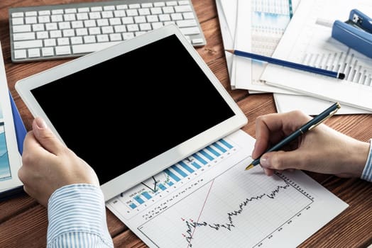 close-up, female hands with tablet. Business woman working at the table in the office