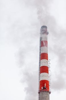 White thick smoke from the boiler room chimney. Smoke against the blue sky. Air pollution. Heating of the city. Industrial zone.