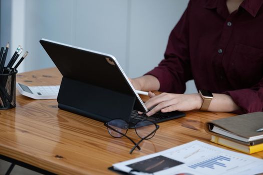 A female company employee is using a tablet computer to search the Internet for information