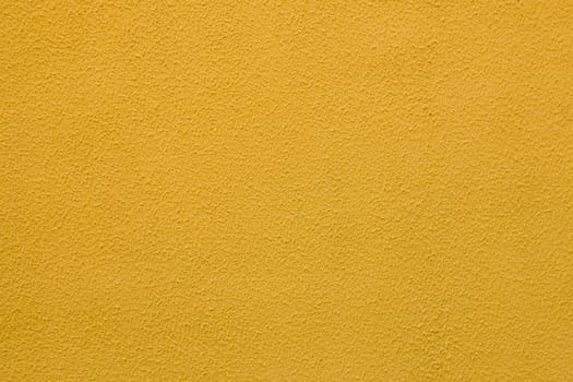 Yellow worn plaster on concrete wall. Old painted cement wall.