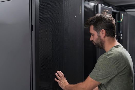 A couple of server engineers cooperate in high tech data centers. Technicians team updating hardware inspecting system performance in super computer server room or cryptocurrency mining farm.