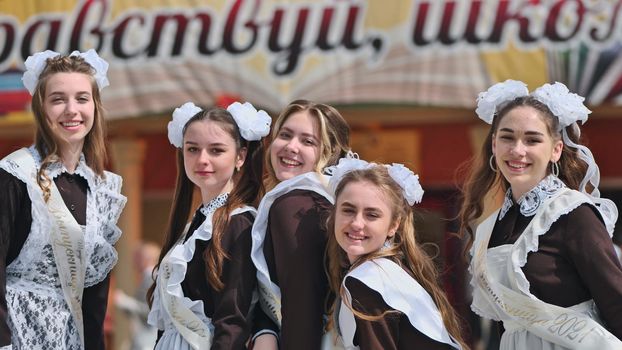 Smiling female graduates pose on the last day of school life