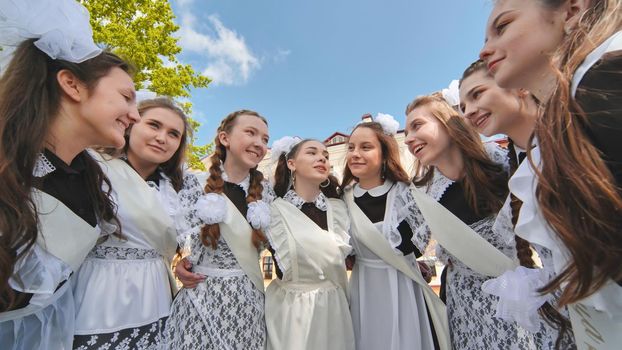 Smiling female graduates pose on the last day of school life