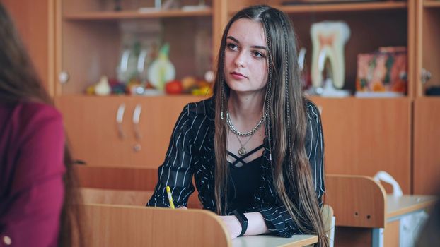 Pupil girl at a desk during a lesson